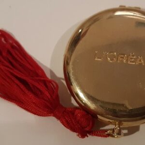 "L'Oréal"miroir rond, ouvrant, biface, façon montre gousset, métal doré bombé. (double)